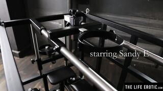 Kinky blonde Sandy E fingers her beaver in a BDSM cage
